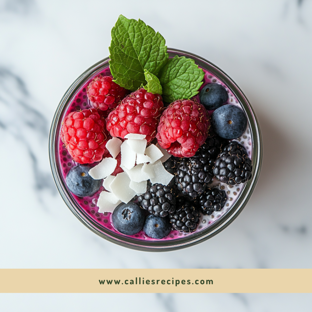 Layered chia seed pudding with berry puree, fresh berries, and coconut flakes in a glass jar